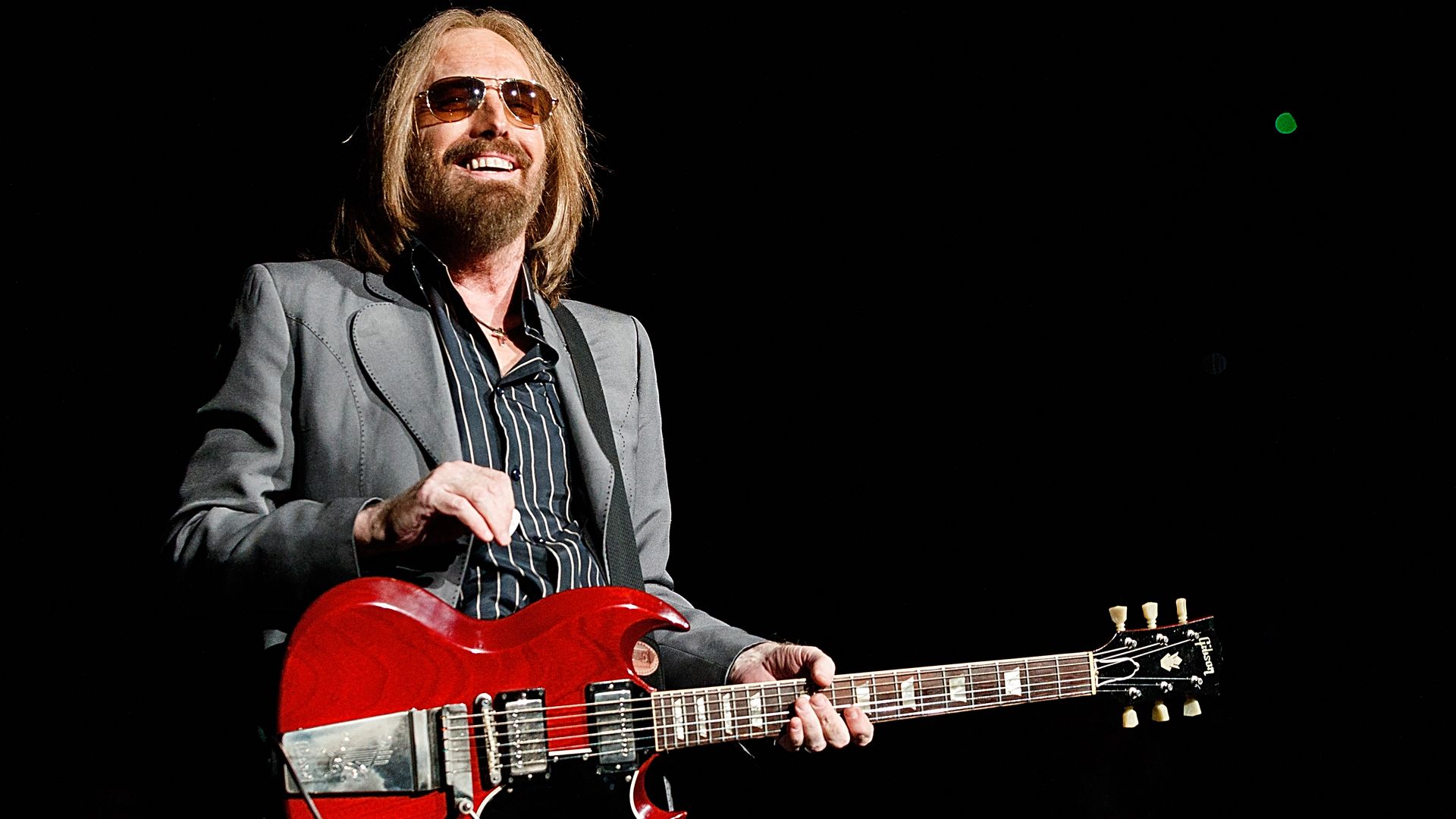 Tom Petty onstage with a guitar in hand