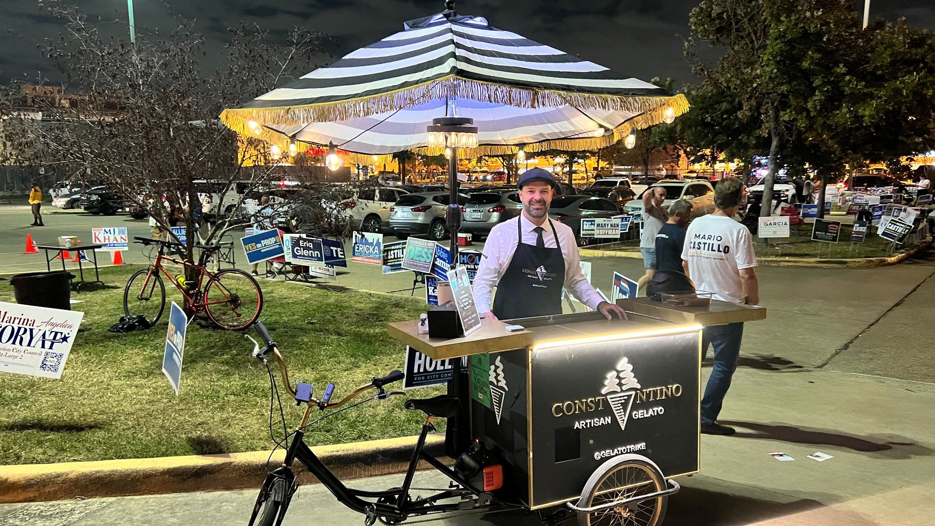 A man stands next to a homemade trike featuring an ice cream cooler