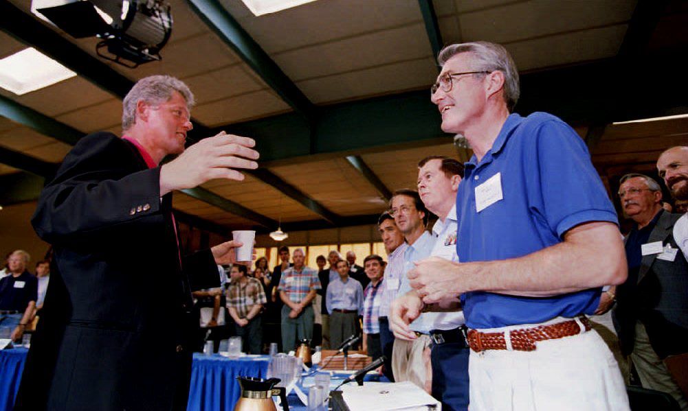 Photo of a man shaking hands with another man at a meeting. 