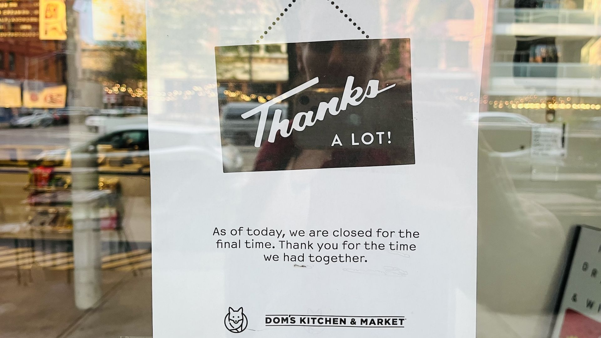 A sign reading "Thanks a lot" on the front door of a store.