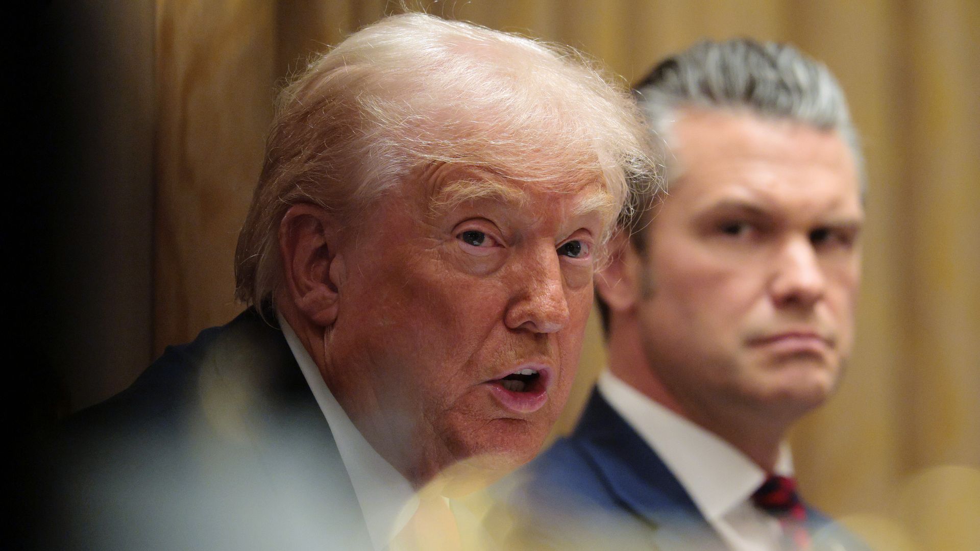President Trump speaks during a Cabinet meeting as Secretary of Defense Pete Hegseth sits beside him and watches.