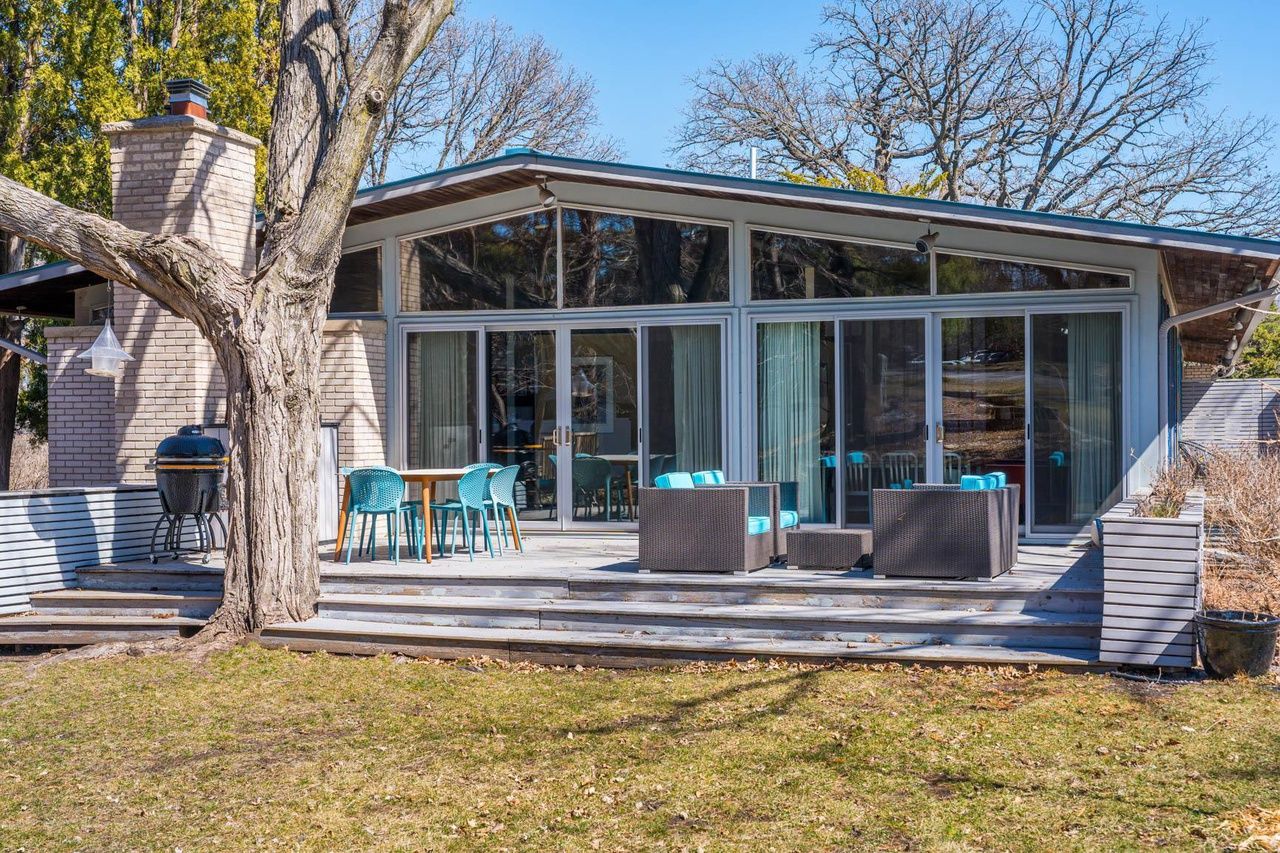 A back patio with glass walls and blue patio furniture.