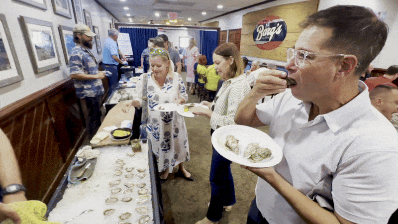 Image shows a man eating a raw oyster