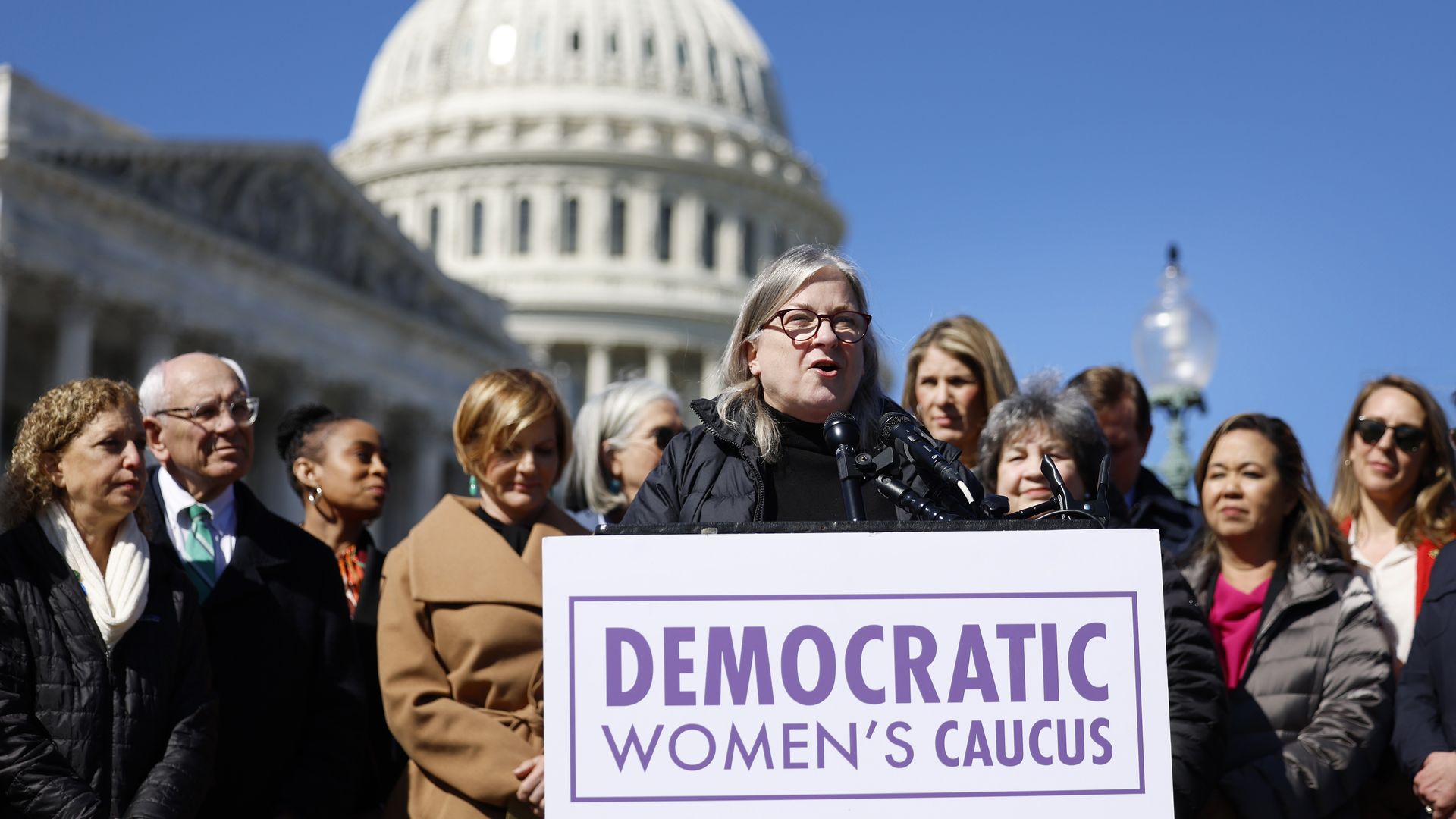 Rep. Susan Wild and other members of the Democratic Women's Caucus standing outside the Capitol wearing coats.