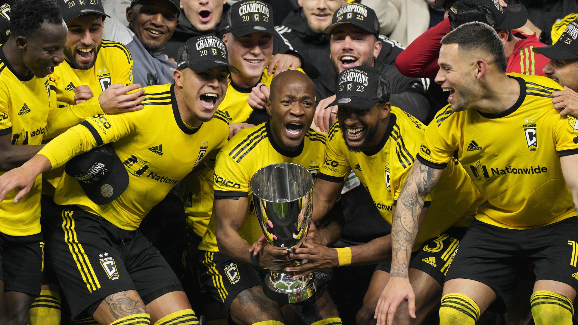 Darlington Nagbe raises the MLS Cup trophy surrounded by teammates
