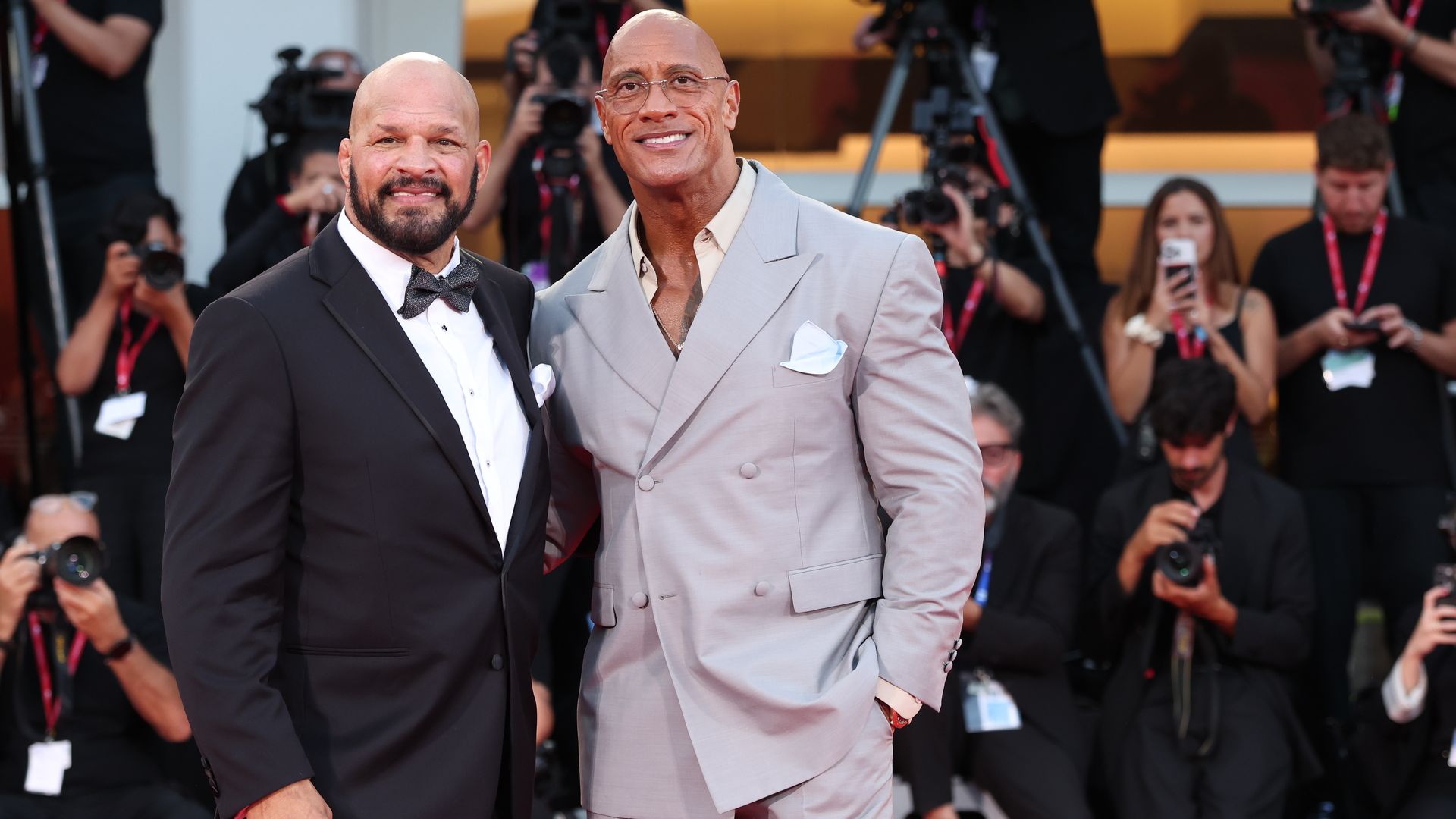 Dwayne Johnson stands next to Mark Kerr at the Venice Film Festival premiere of "The Smashing Machine"