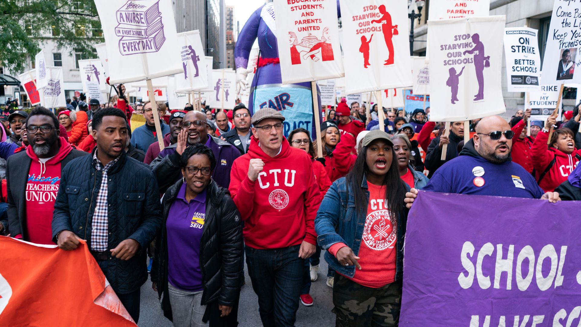 Photo of a group marching with protest signs. 