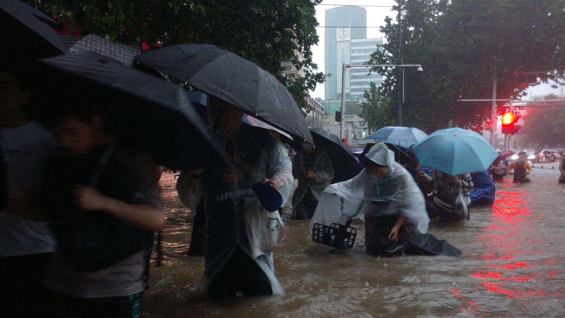 People walking down a flooded road in Zhengzhou, China, on July 20.