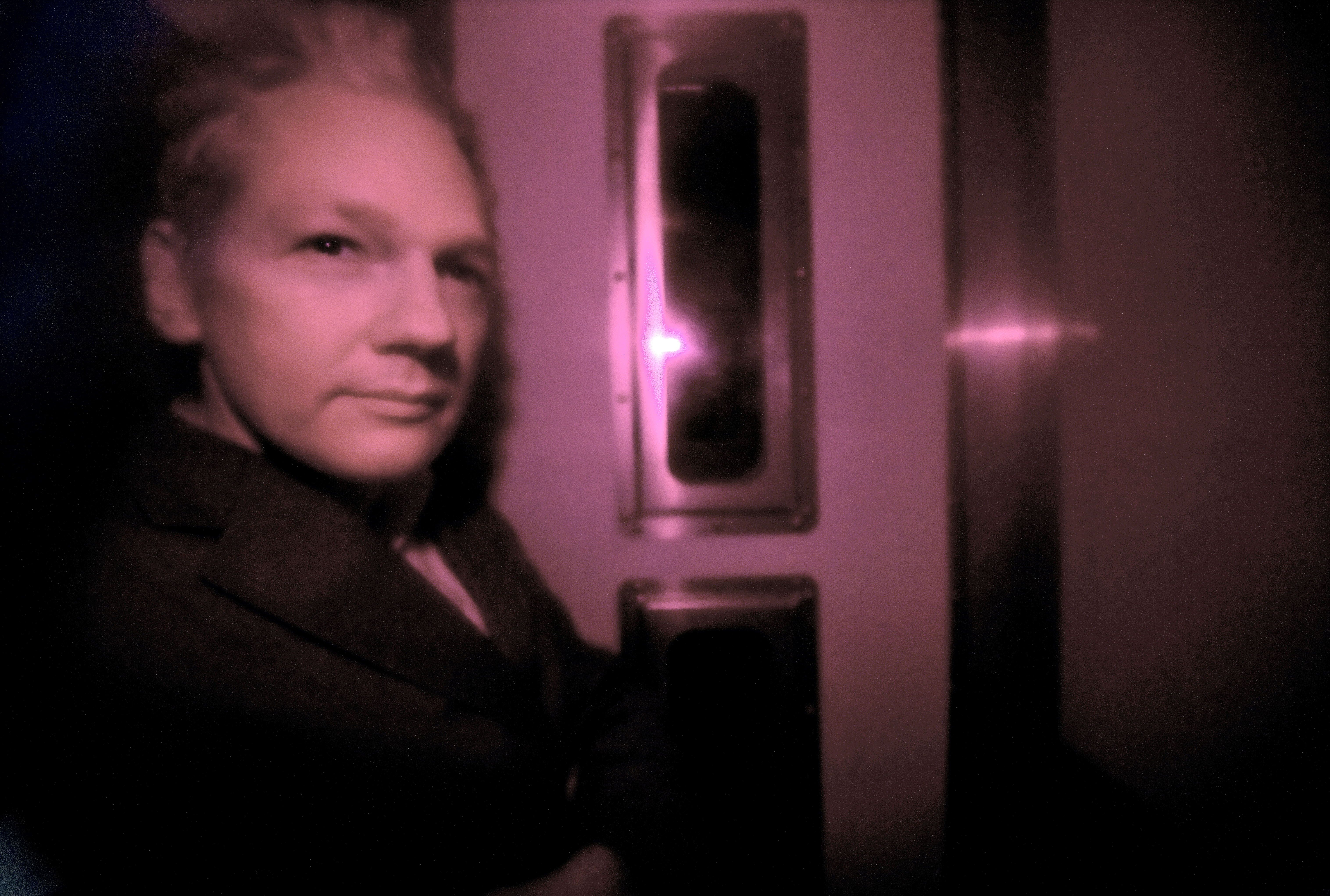 Wikileaks founder Julian Assange is pictured through the heavily tinted windows of a police vehicle as he arrives at Westminster magistrates court in London, on December 14, 2010