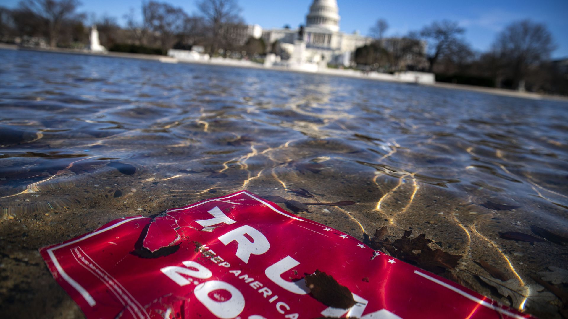 Trump campaign sign floats in river near the Capitol building.