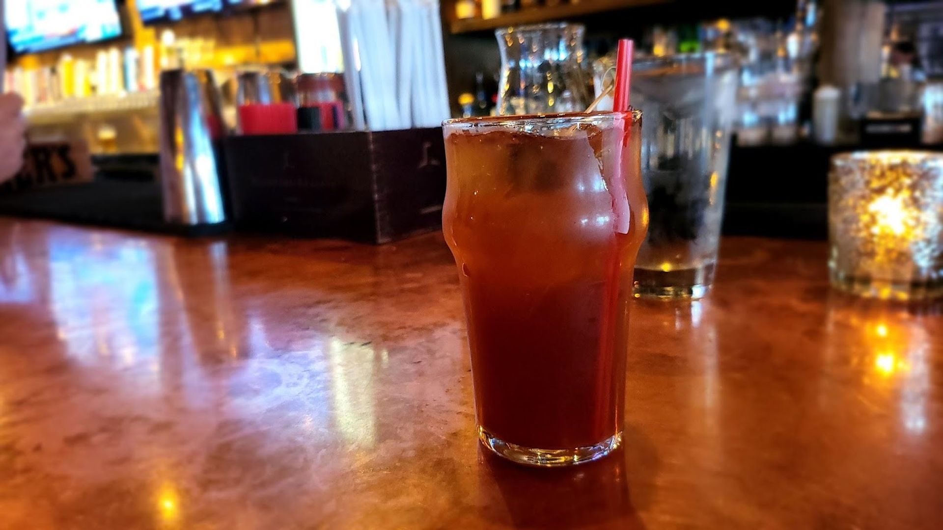 A brown cocktail on a bar.
