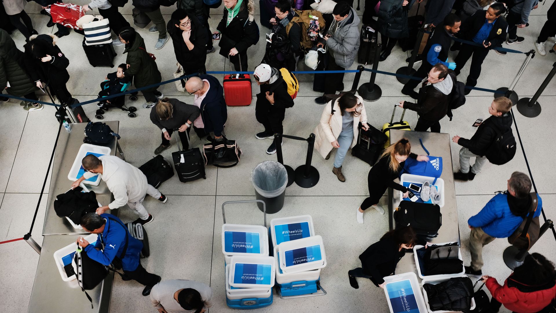 Passengers wait in a Transportation Security Administration (TSA) line at JFK airport 