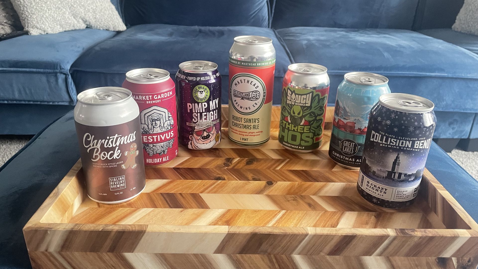 Seven cans of Cleveland-area Christmas Ales, arrayed in a half circle.