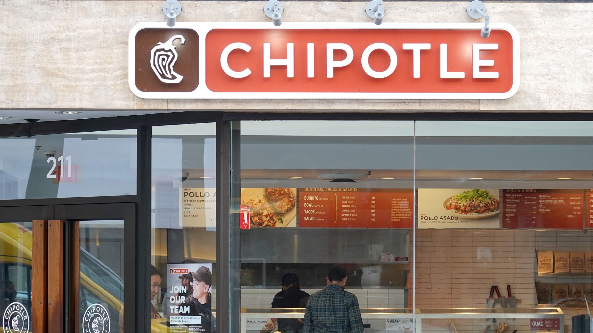 A customer orders food at a Chipotle restaurant