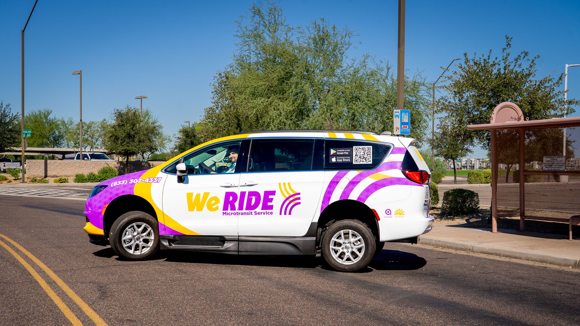 A white minivan with purple and yellow markings and the words We Ride on the side.