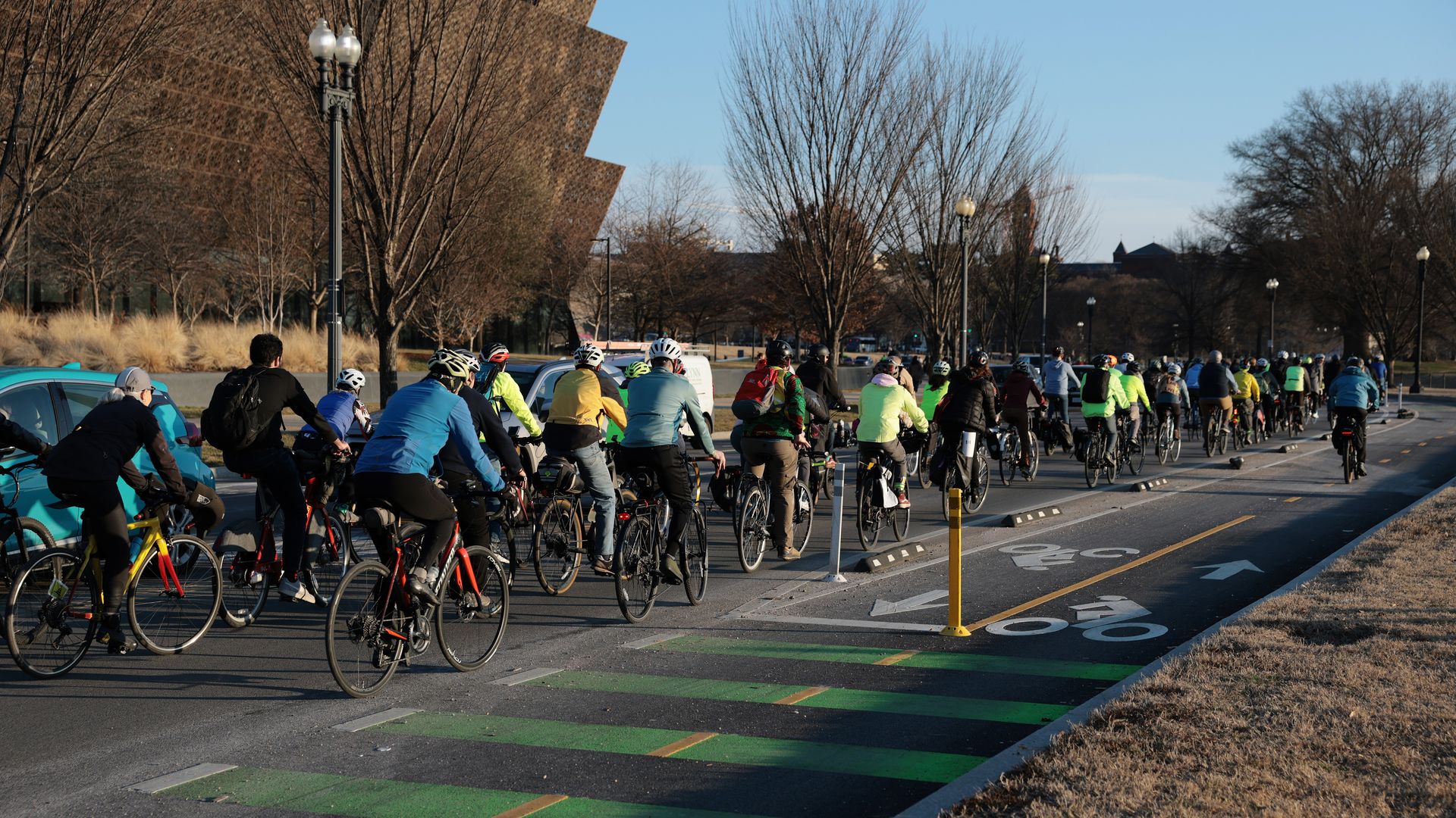 A large group of cyclists ride down 15th Street on the National Mall
