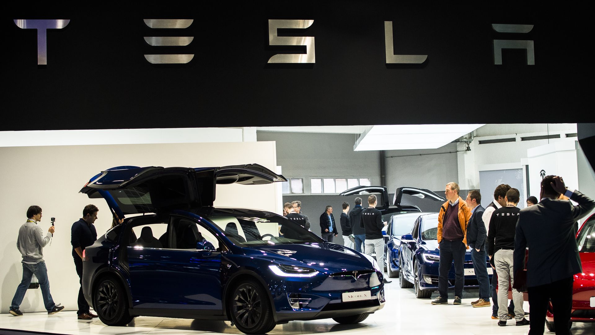 Photo of Tesla with people circulating around it at Brussels auto show in 2019