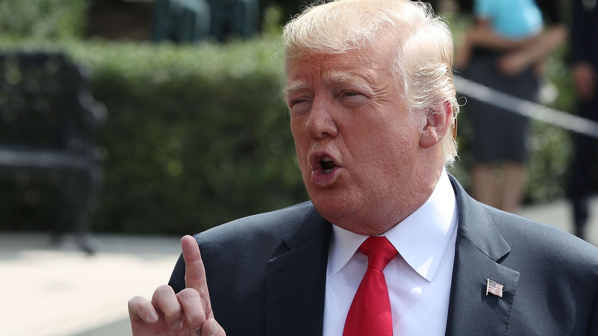 Trump lifts a finger while speaking to reporters