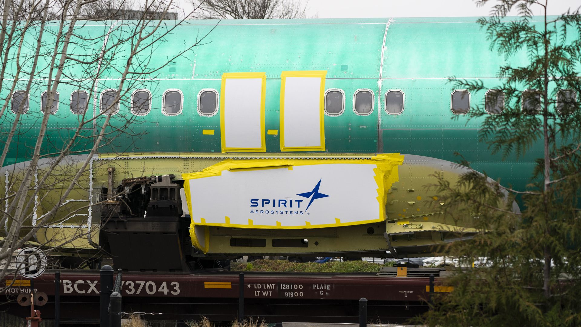 Spirit AeroSystems signage on a Boeing 737 fuselage in a manufacturing facility.