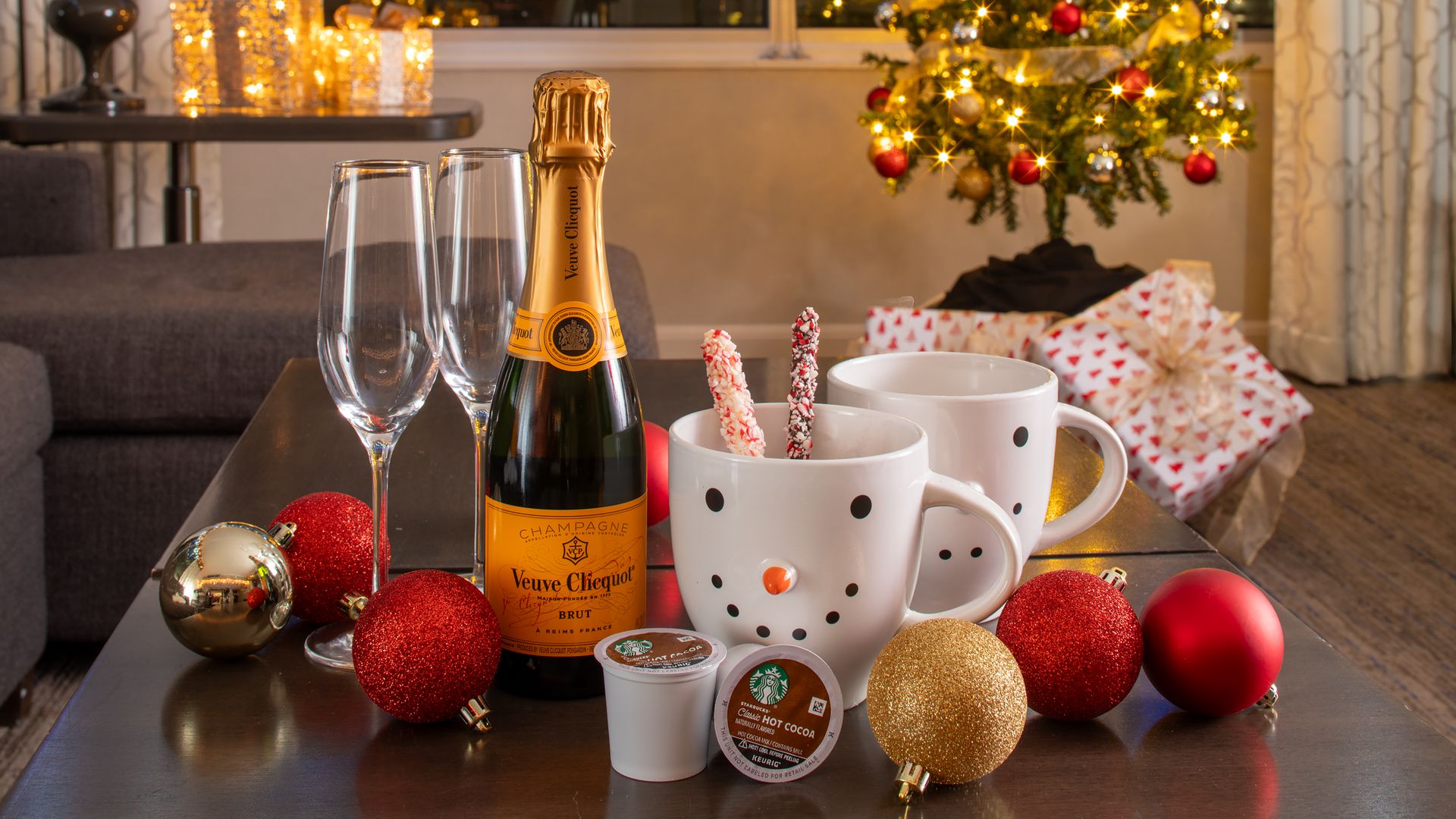 A table set with snowman mugs, champagne and Christmas decorations.