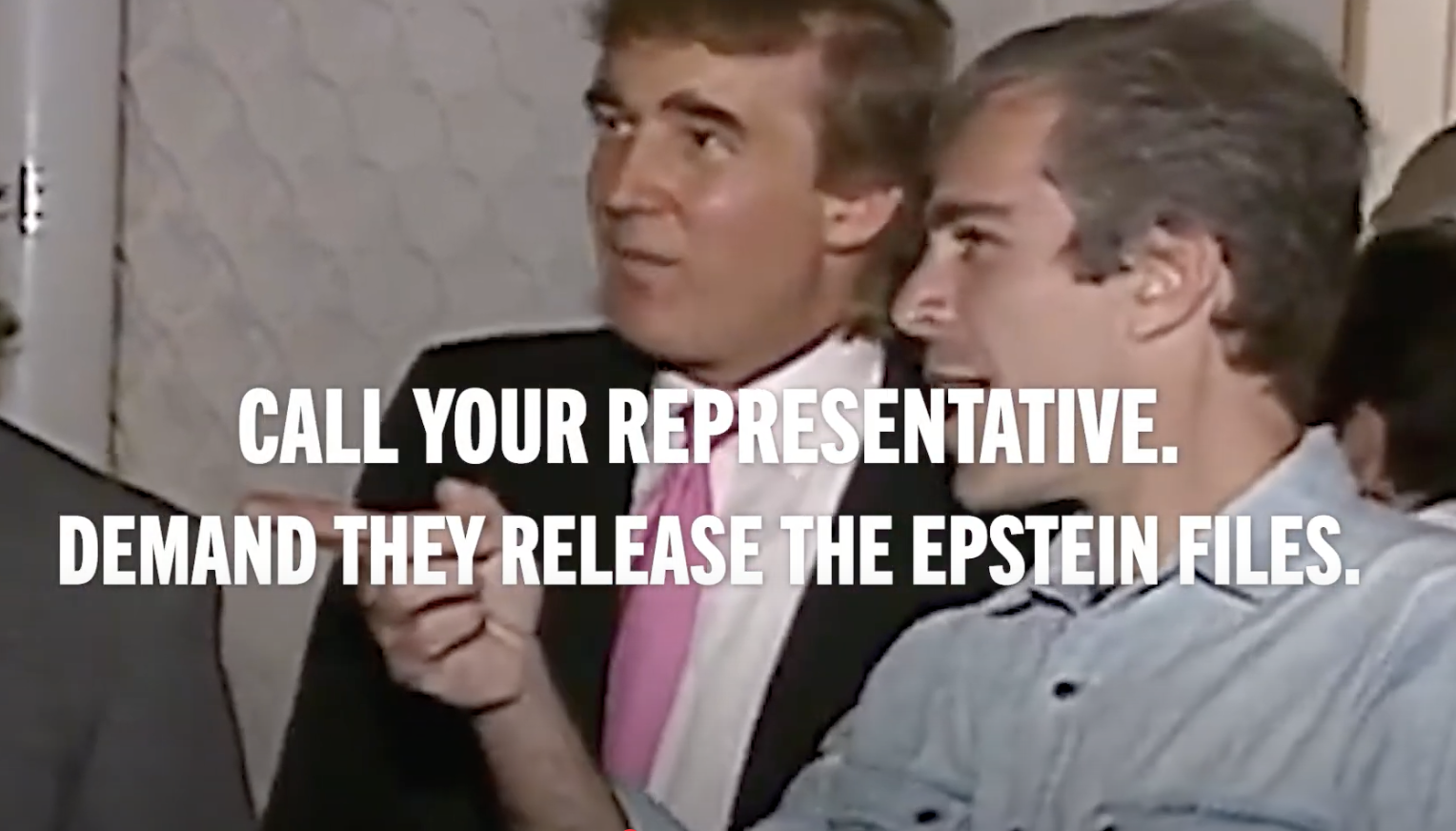 Two men in a conversation, one wearing a black suit with a pink tie and the other in a light denim shirt. White text overlay says, "Call your representative. Demand they release the Epstein files."