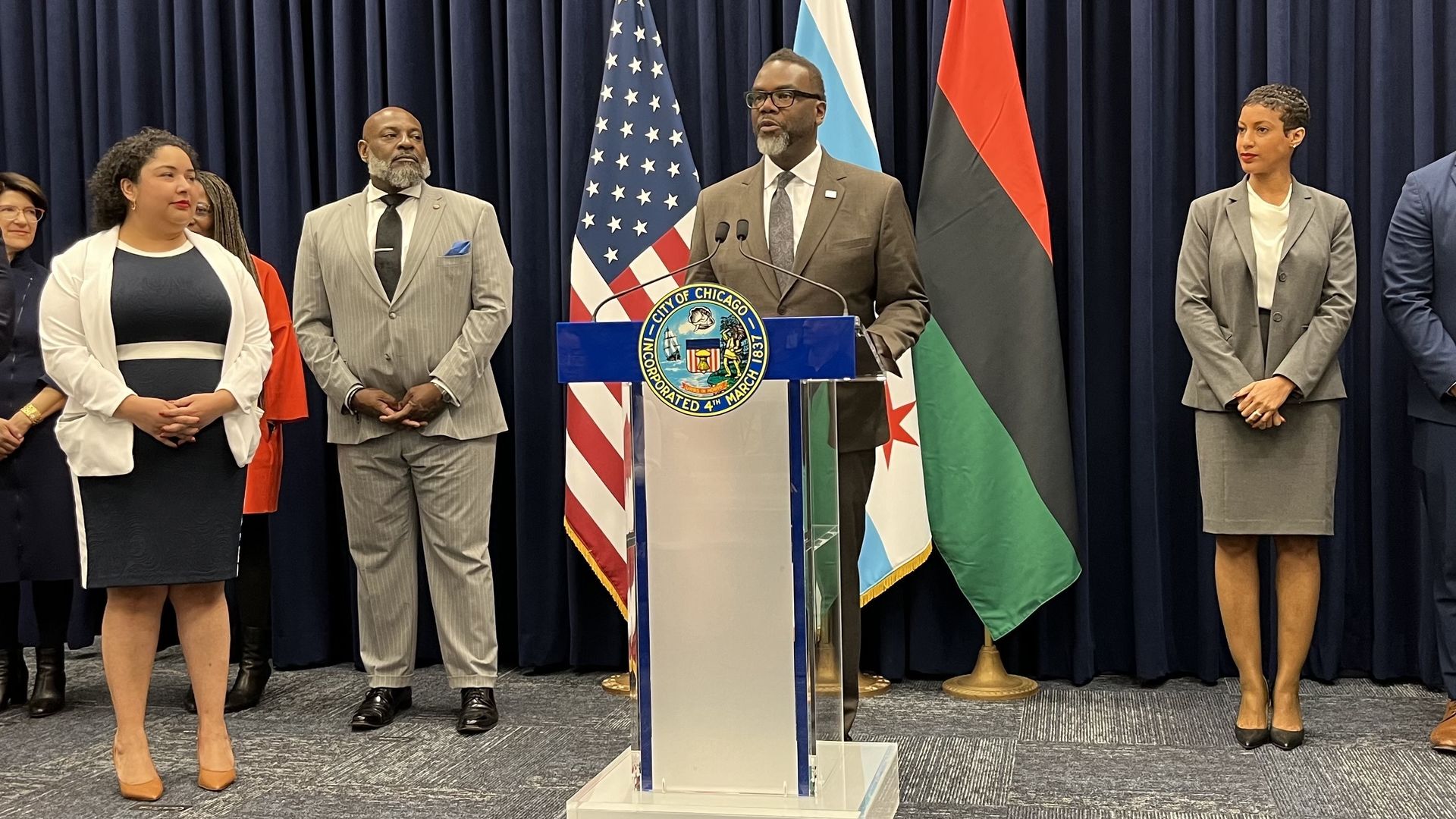 Photo of a man standing behind a podium giving a speech