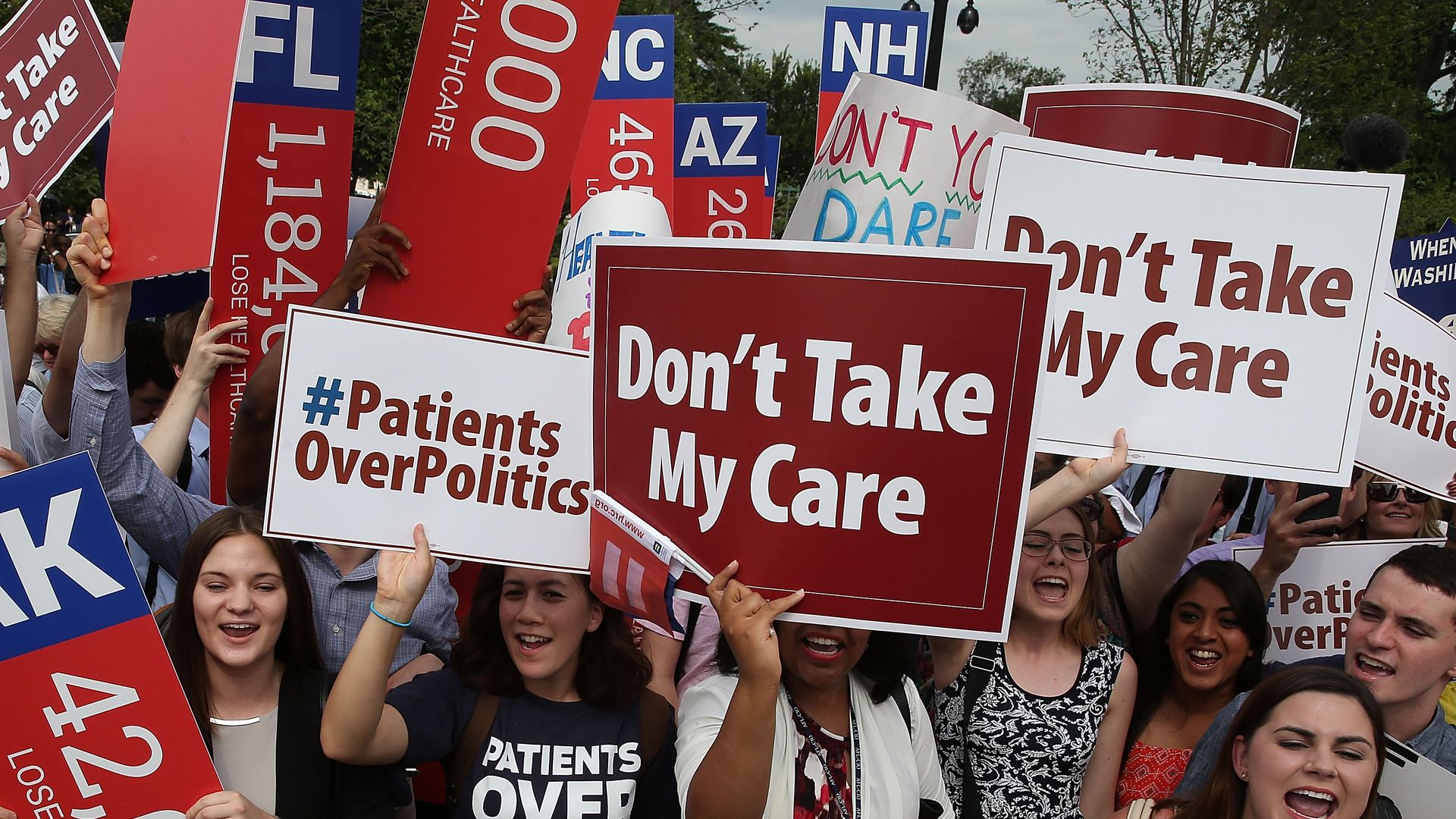 Protester hold signs outside of the Supreme Court during an Affordable Care Act case.