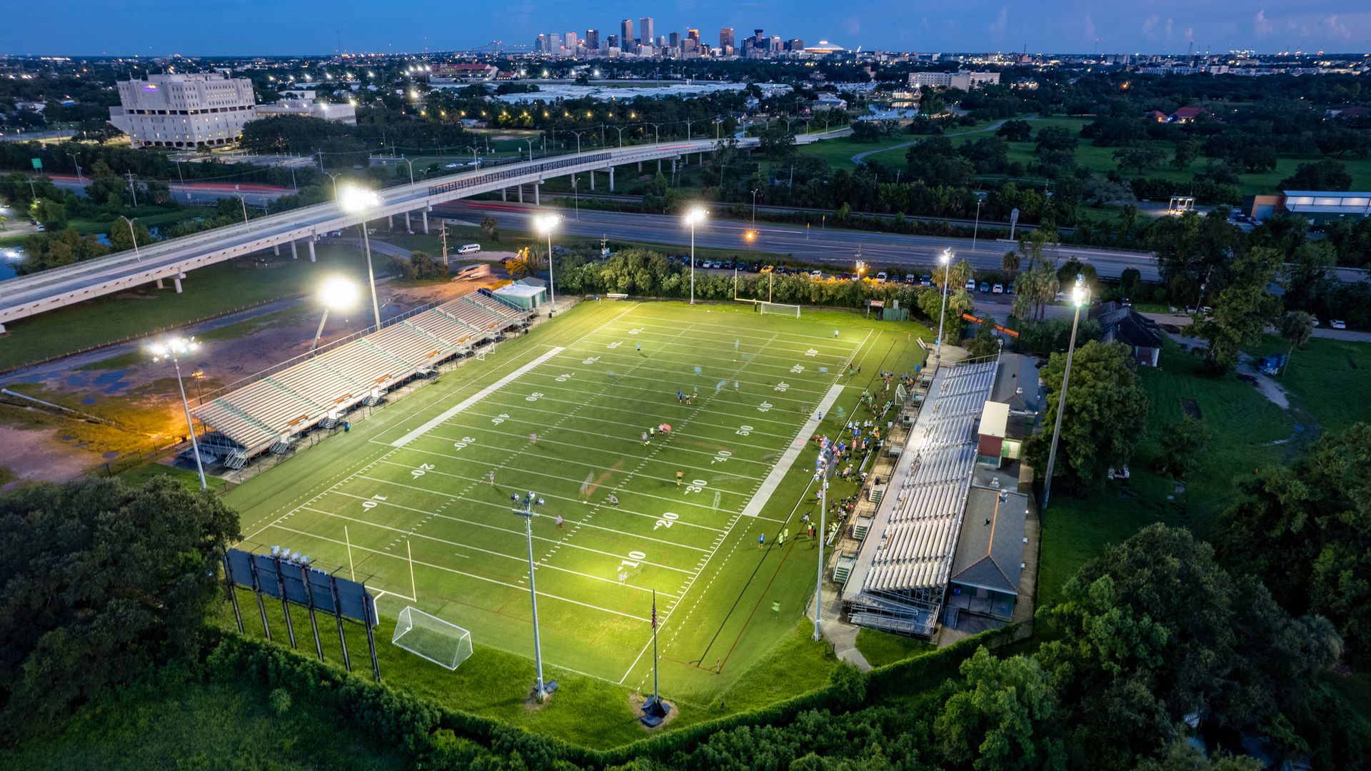 A bird's-eye view of Pan American Stadium at night as a football team plays.