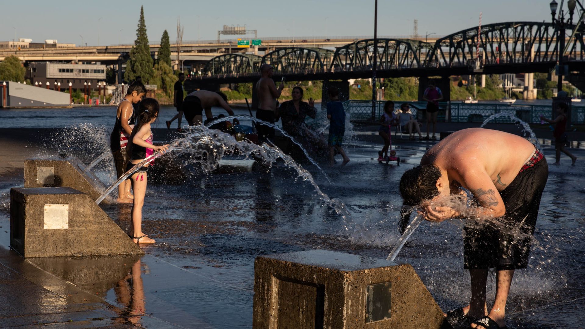 Children play at a water fountain splash park in Oregon during a record heat wave.