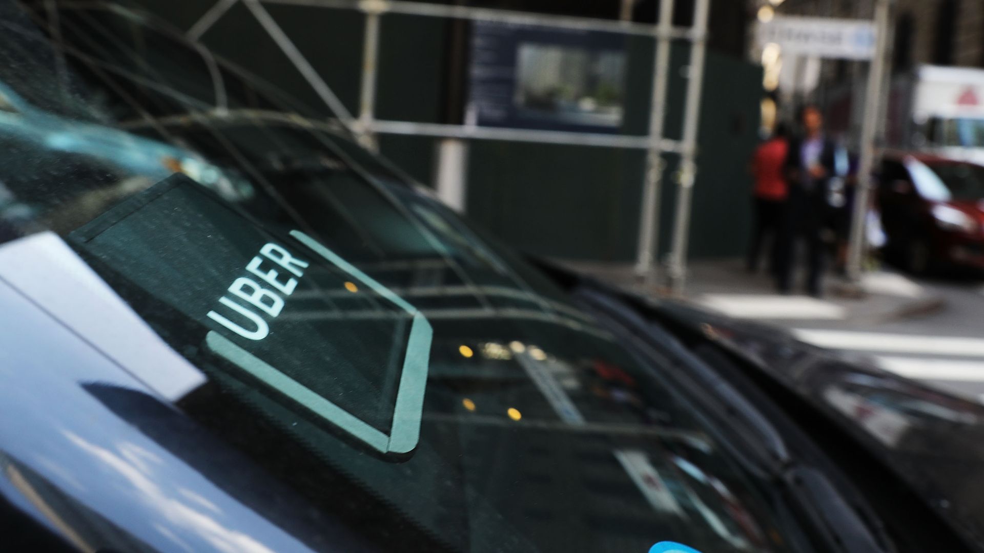 Photo of a car with an Uber logo sticker plastered on the windshield