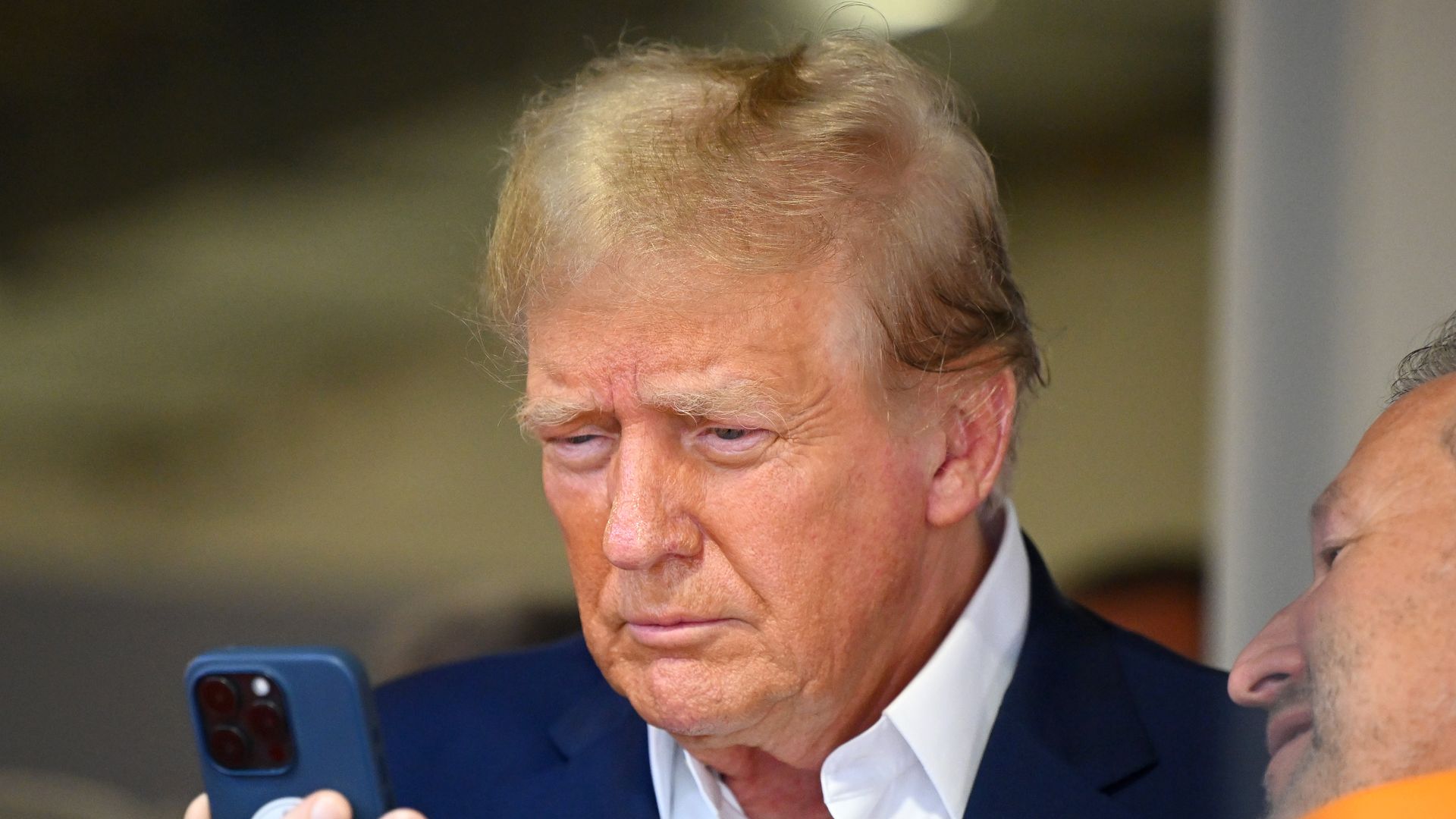 Trump looks at his phone.