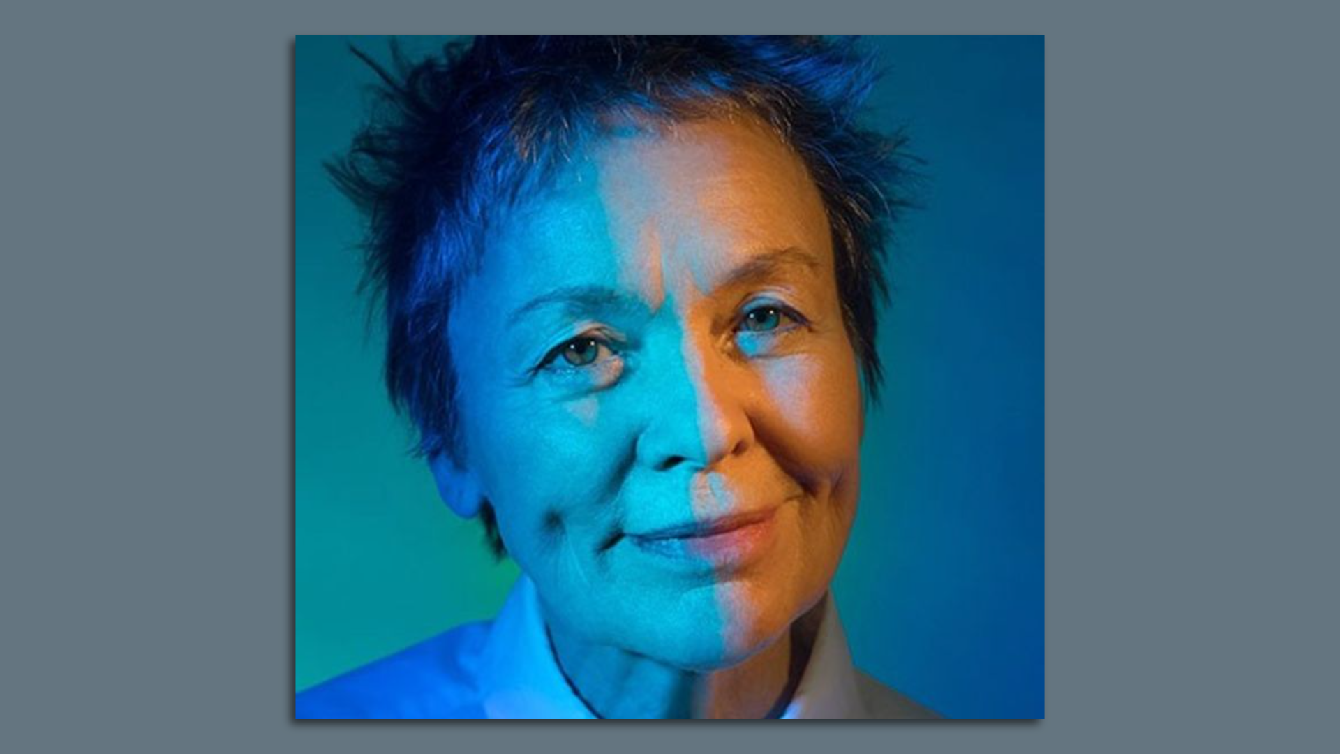 Portrait of a smiling, elderly white woman with short, spiky hair and dimples in a white collared shirt