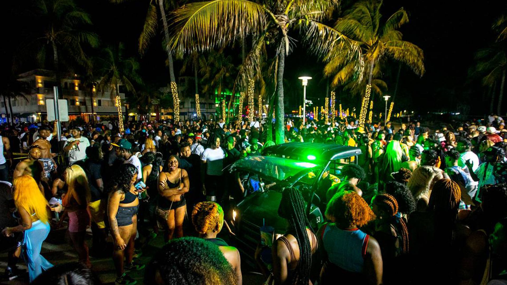 A Miami Beach Police vehicle cuts through crowds near Ocean Drive during Spring Break in Miami Beach, Florida, on Saturday, March 19, 2022.