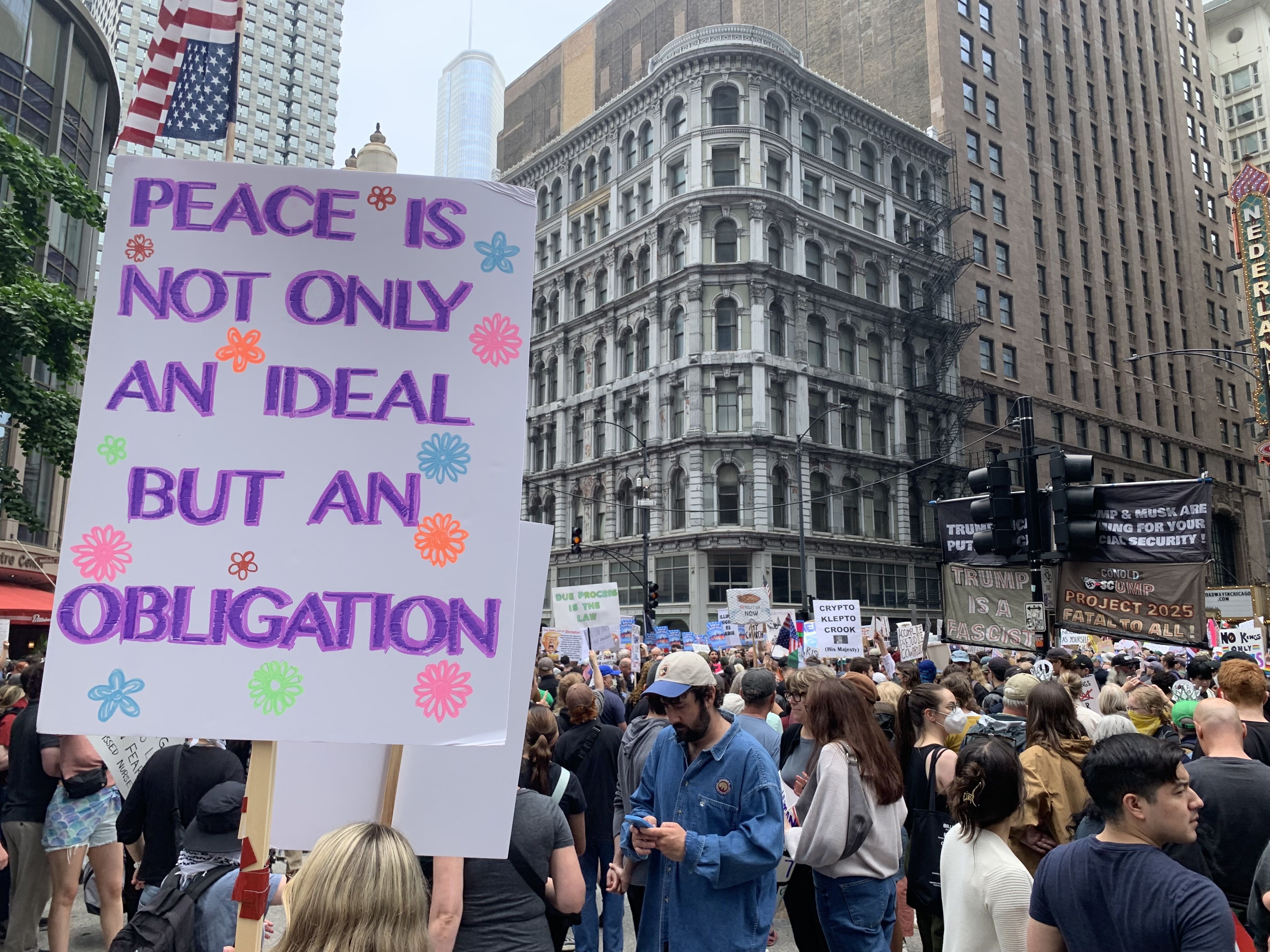 Protesters fill up a plaza with signs and march on a street. 