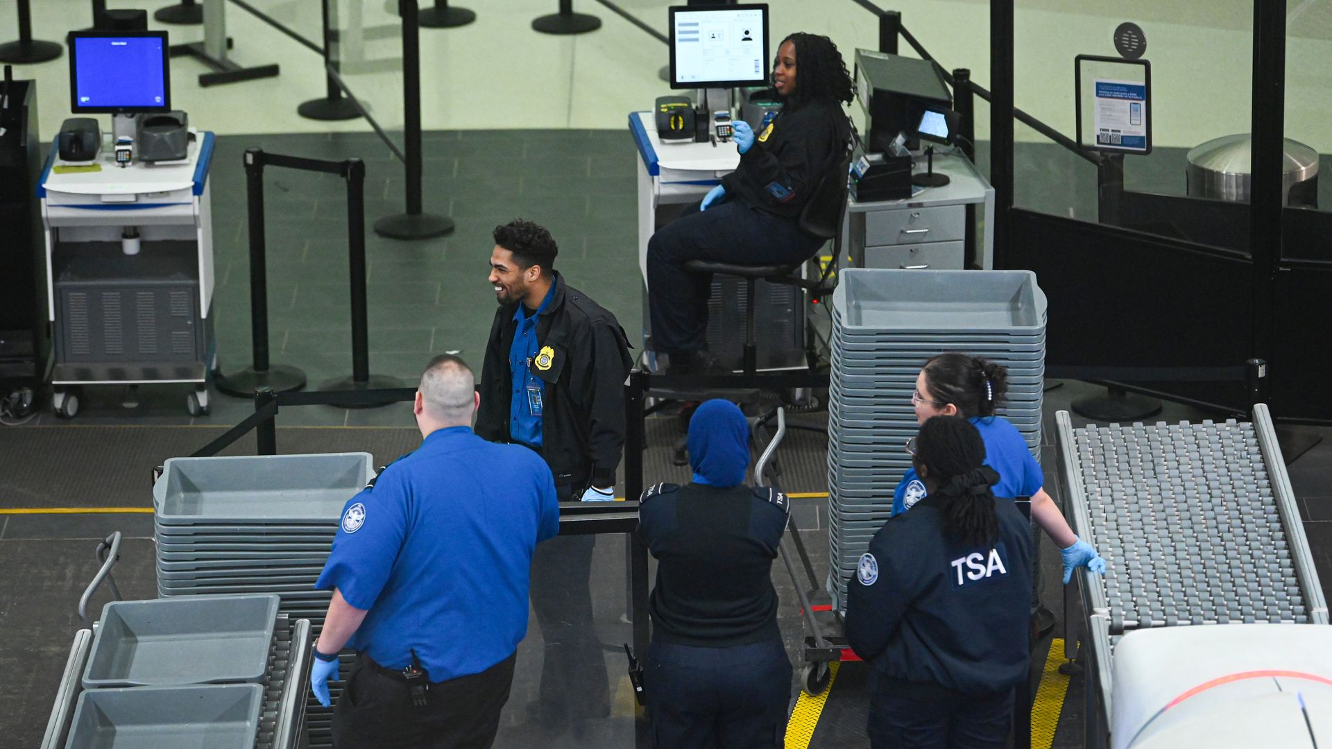 Transportation Security Administration workers wait for travelers at the security checkpoint at Albany International Airport on March 23,
