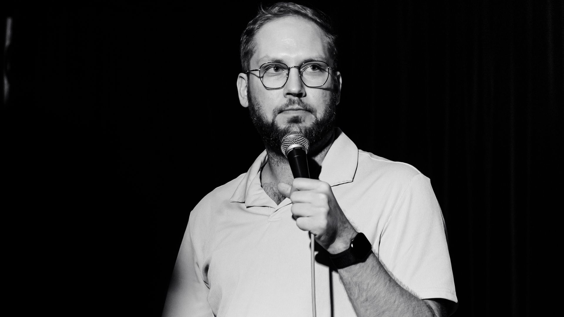 Comedian Kyle Ayers with a mic in his hand at one of his standup performances.