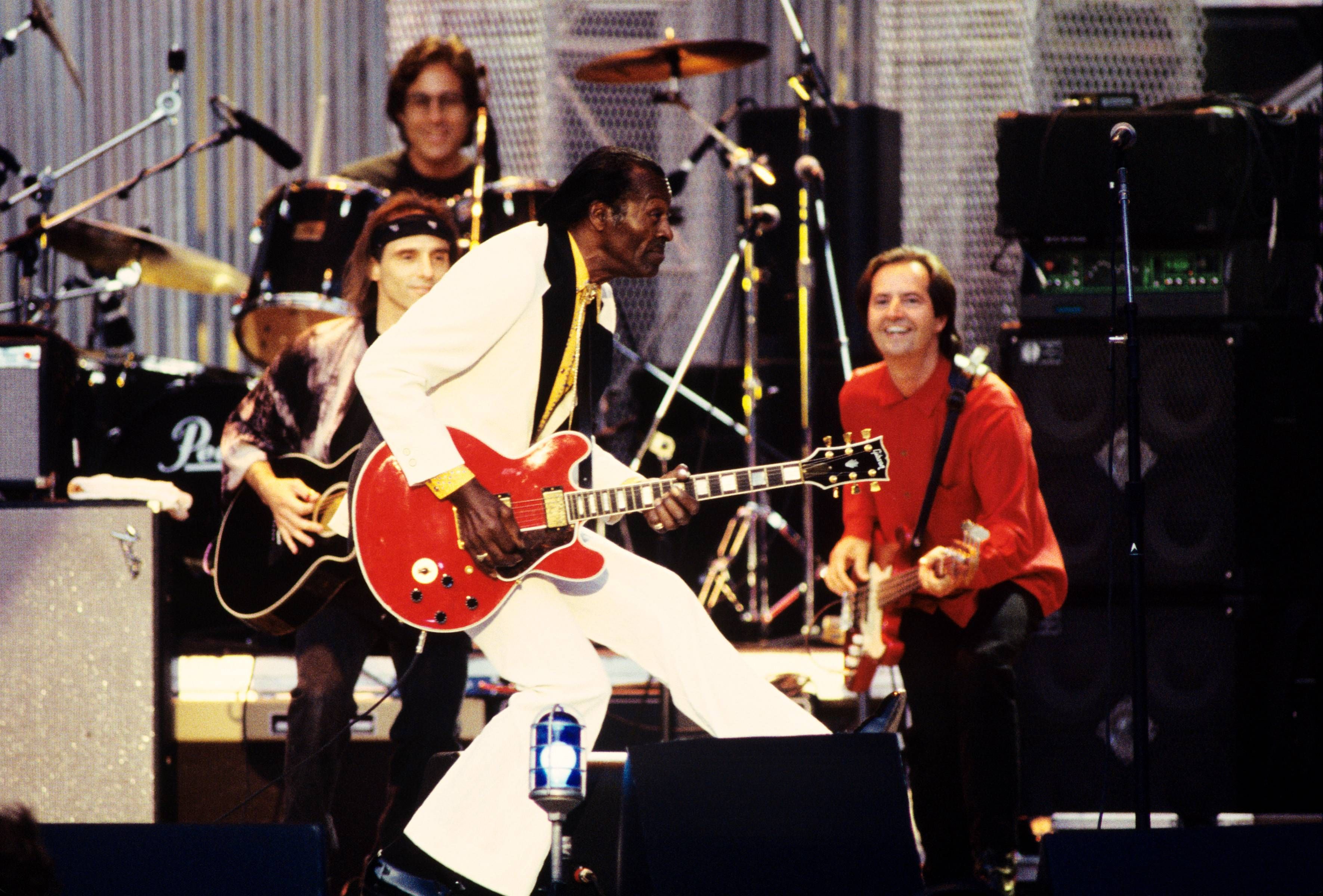 Chuck Berry duck walks on stage. 