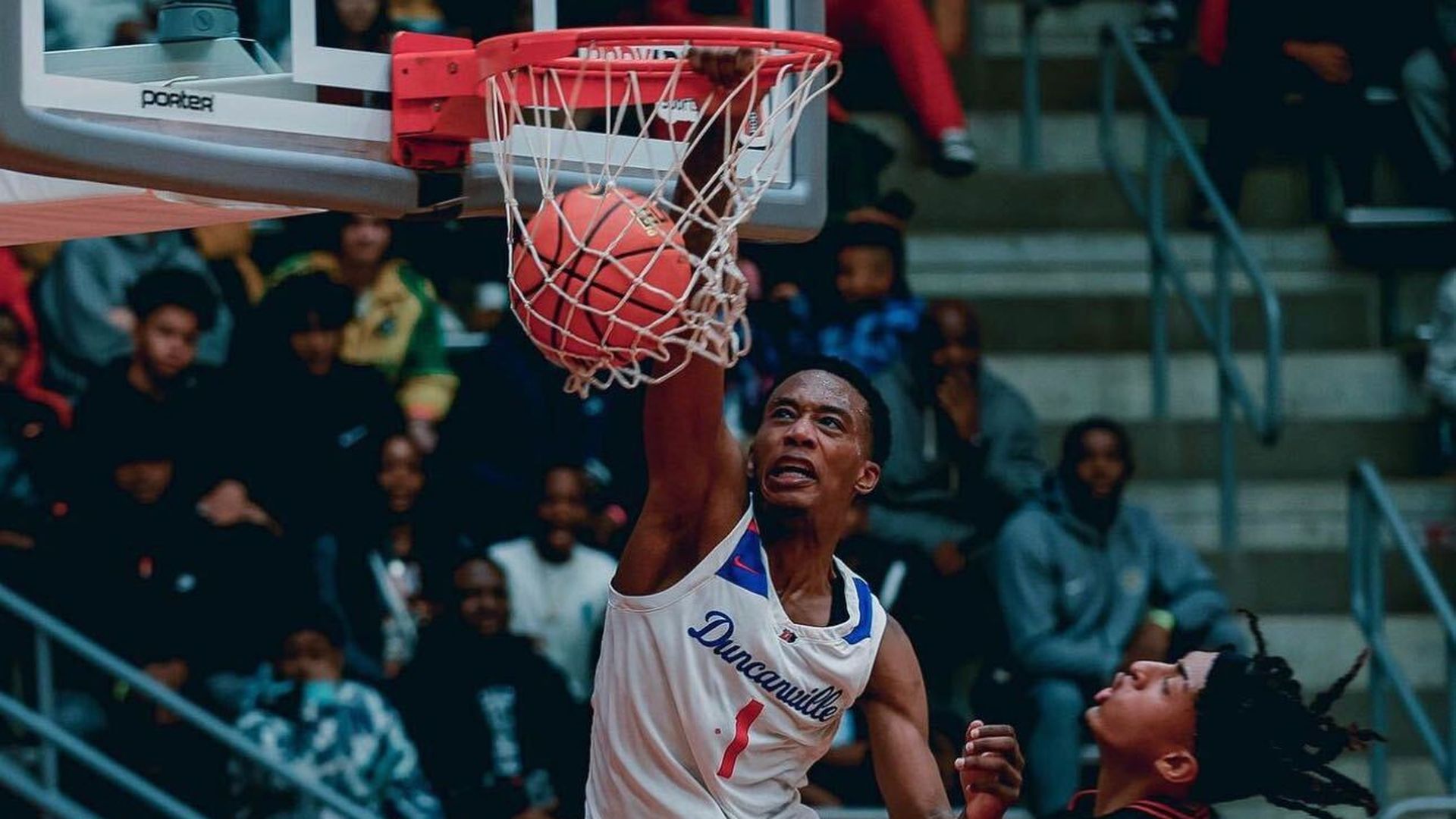 A Duncanville high school student dunks a basketball