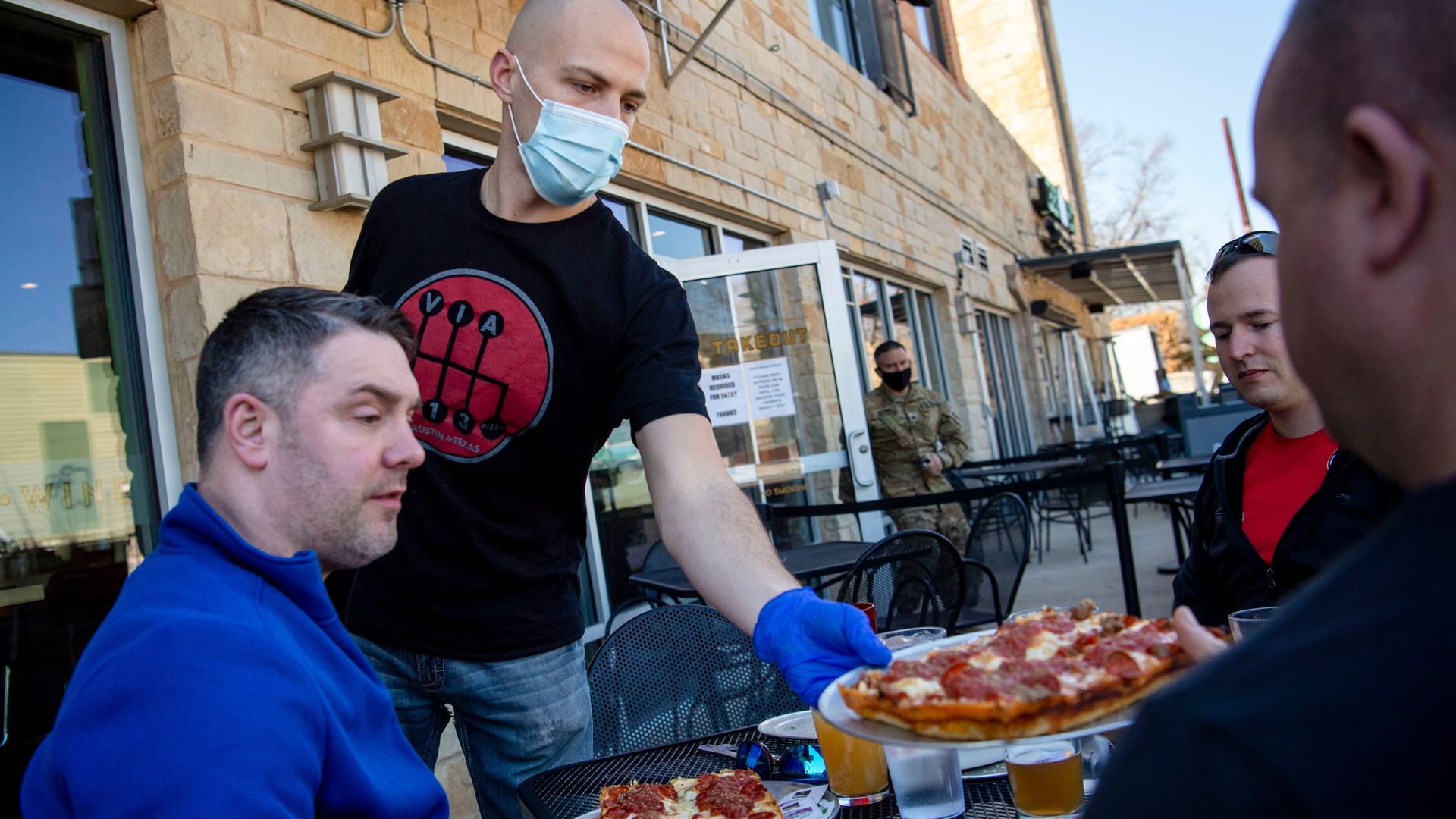 A server brings pizza to a table.