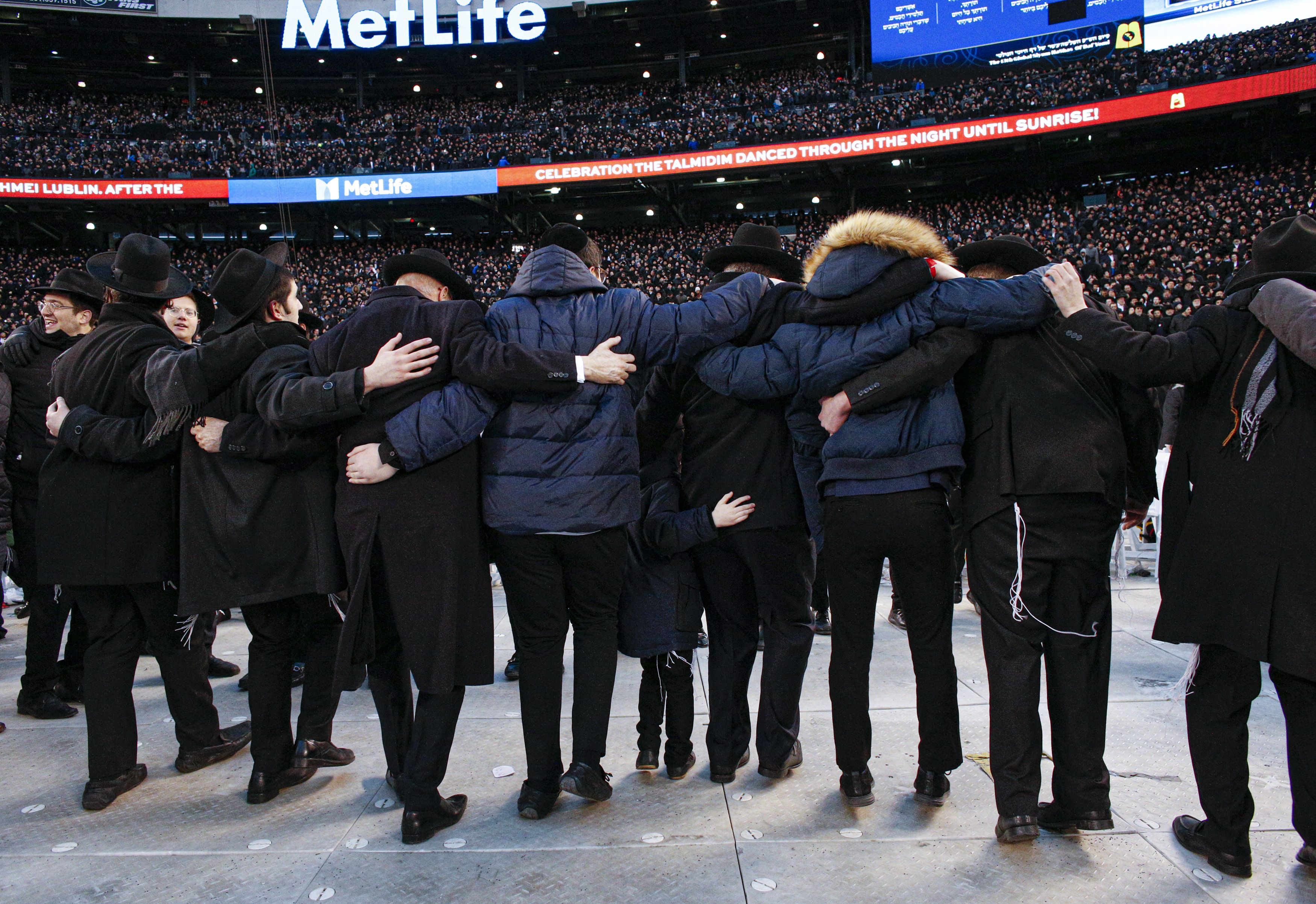 Men dance as they gather with others in MetLife Stadium on January 1, 2020, in East Rutherford