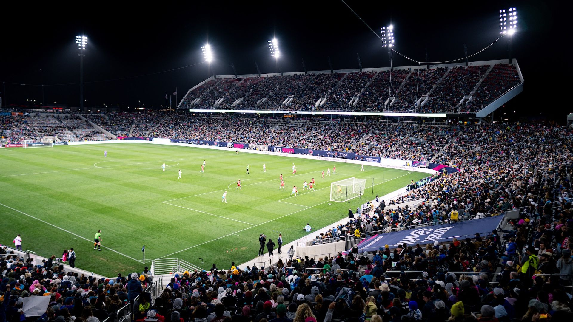 A wide view of a soccer field at Snapdragon Stadium from the crowd at night.