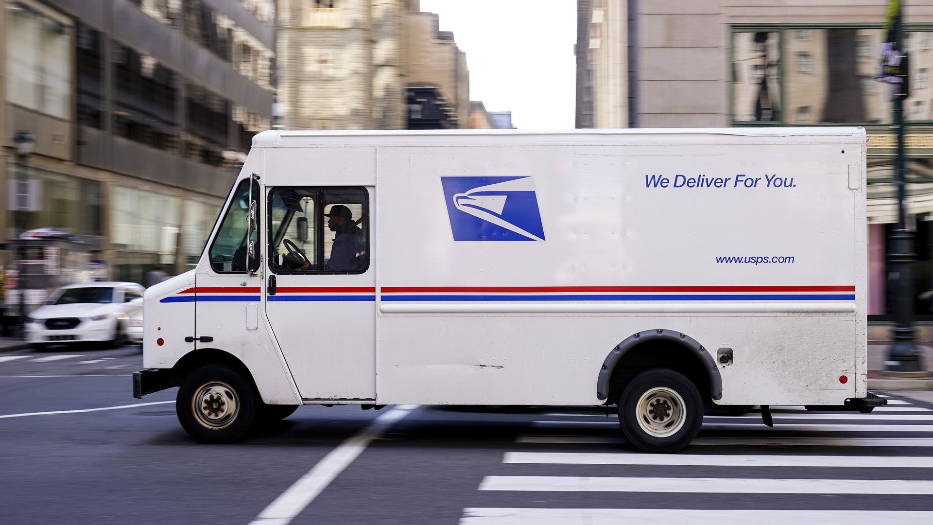 A United States Postal Service truck drives in downtown Philadelphia.