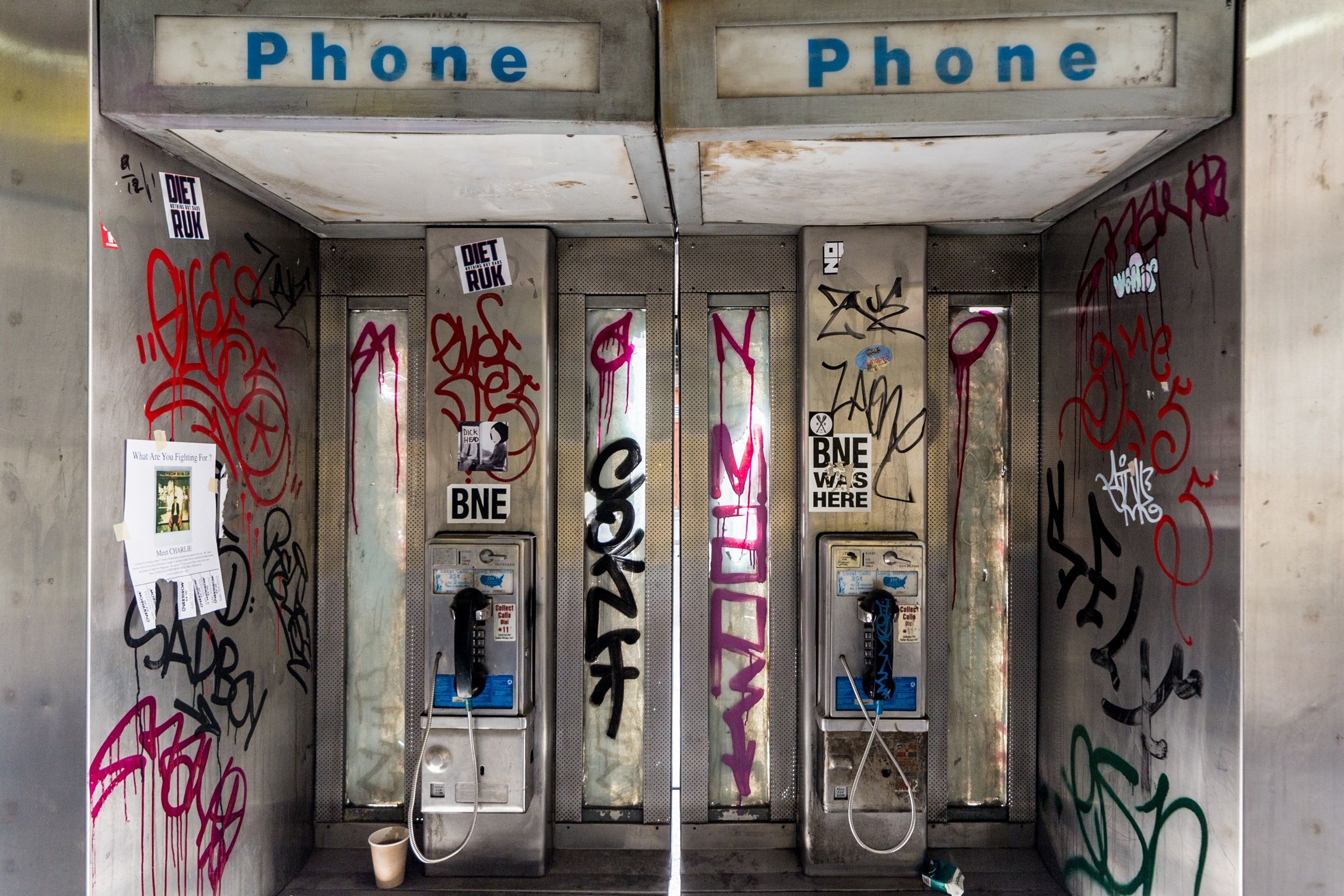 A pair of graffiti-covered pay phones in New York City, 2015.