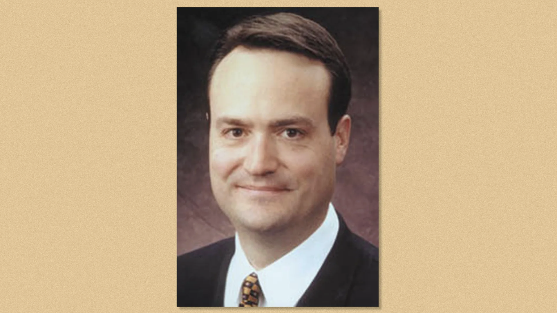 Tom Burnett, smiling slightly against a dark brown backdrop.
