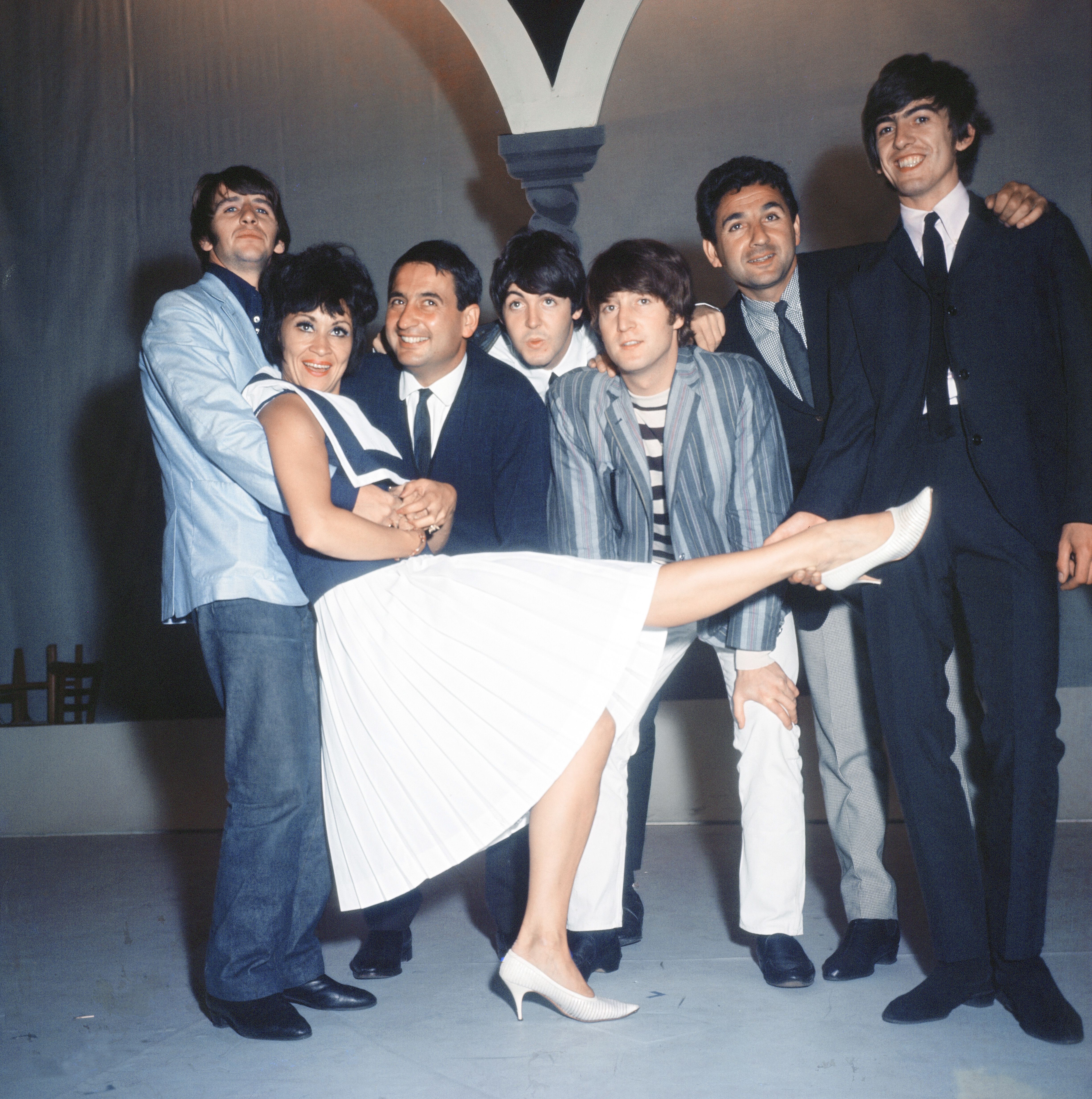 Members of the Beatles and two men hold Chita Rivera