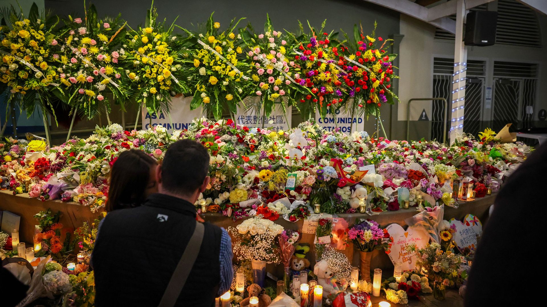 people pay their respects after a candlelight vigil