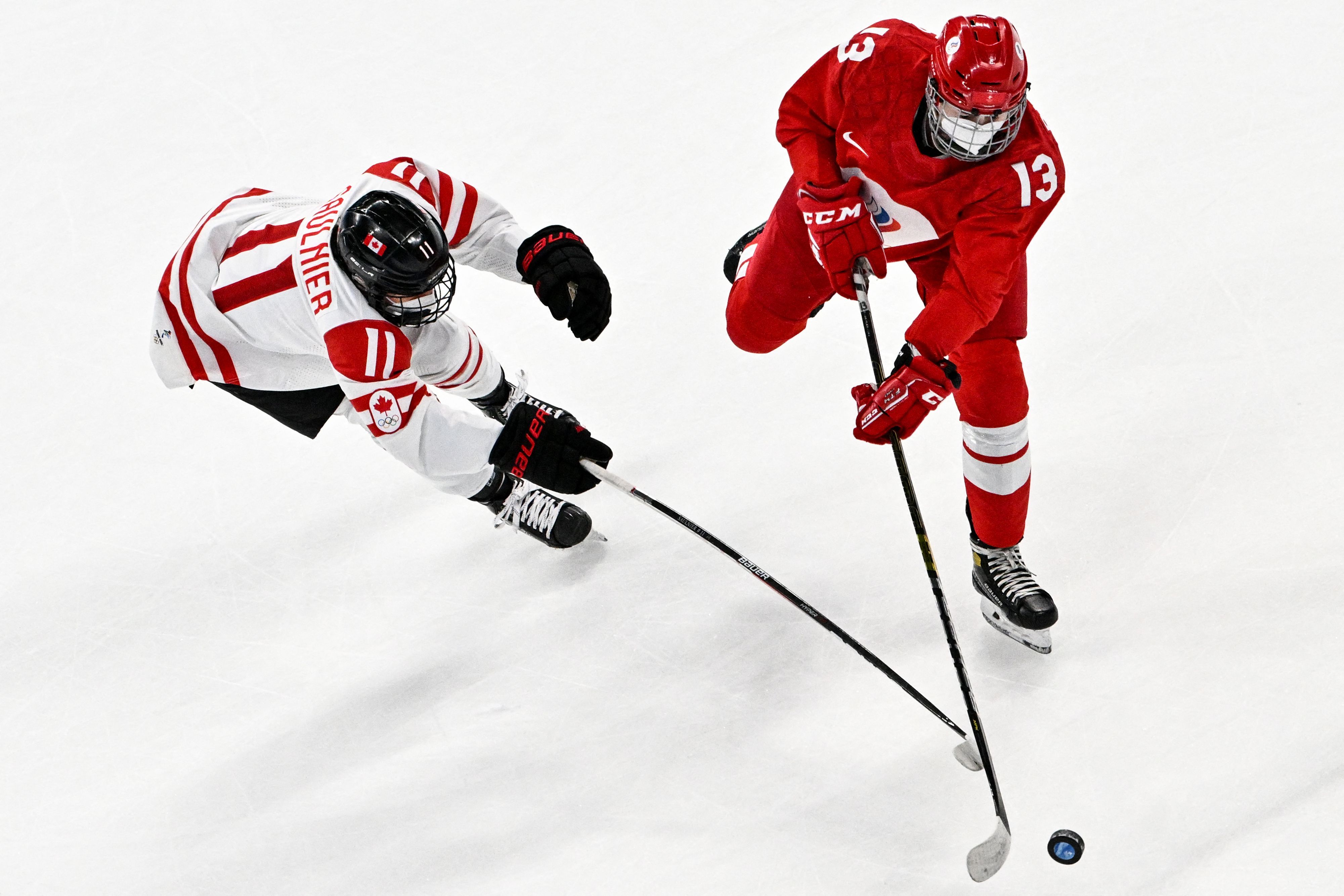 Canada's Jillian Saulnier and Russian Olympic Commitee's Nina Pirogova vie for the puck during the women's preliminary round group A match of the Beijing 2022 Winter Olympic Games