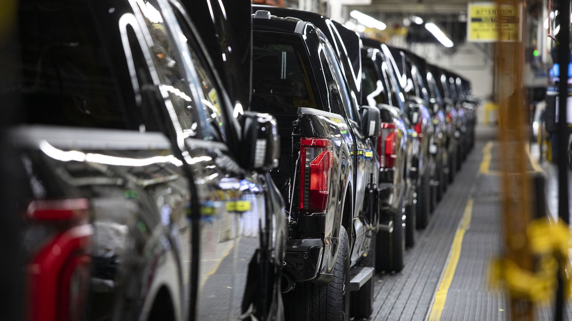 Image of a line of Ford F-150 pickup trucks going down the assembly line. 