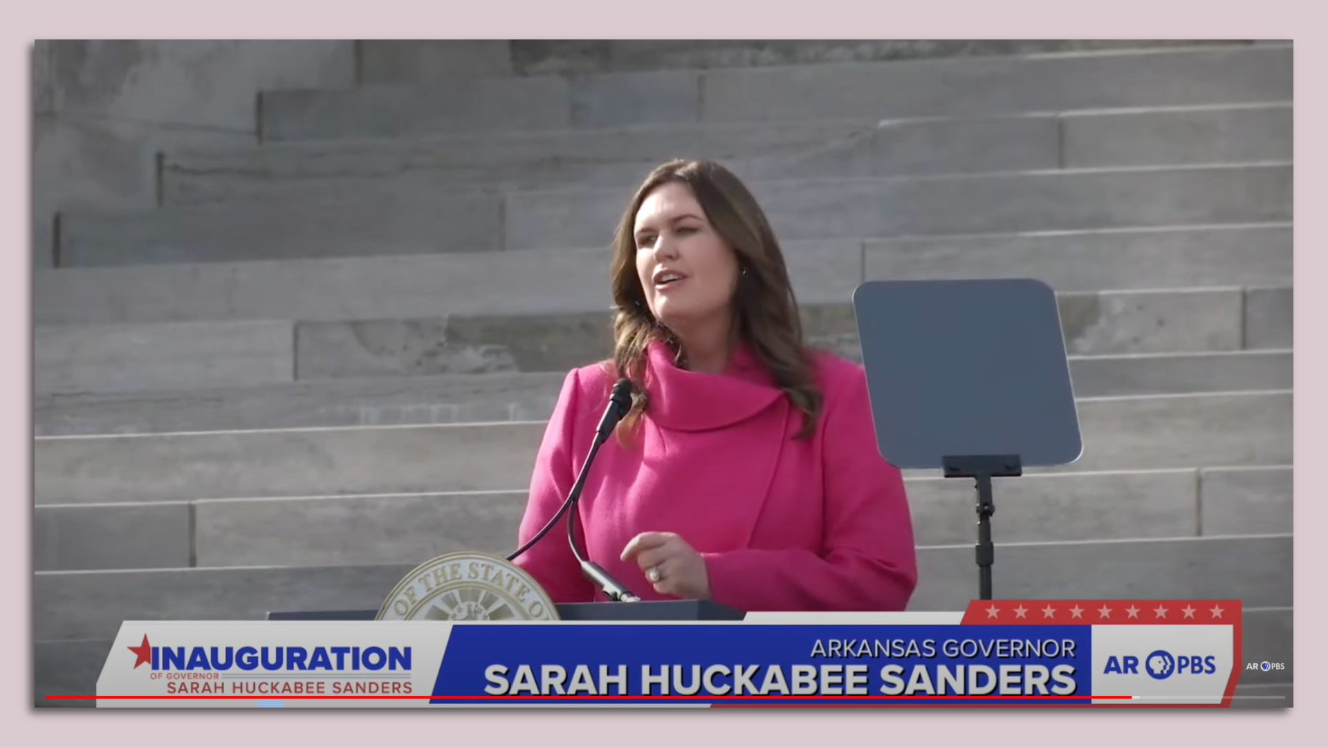 Gov. Sarah Huckabee Sanders speaks from a podium outdoors in her inaugural address. 