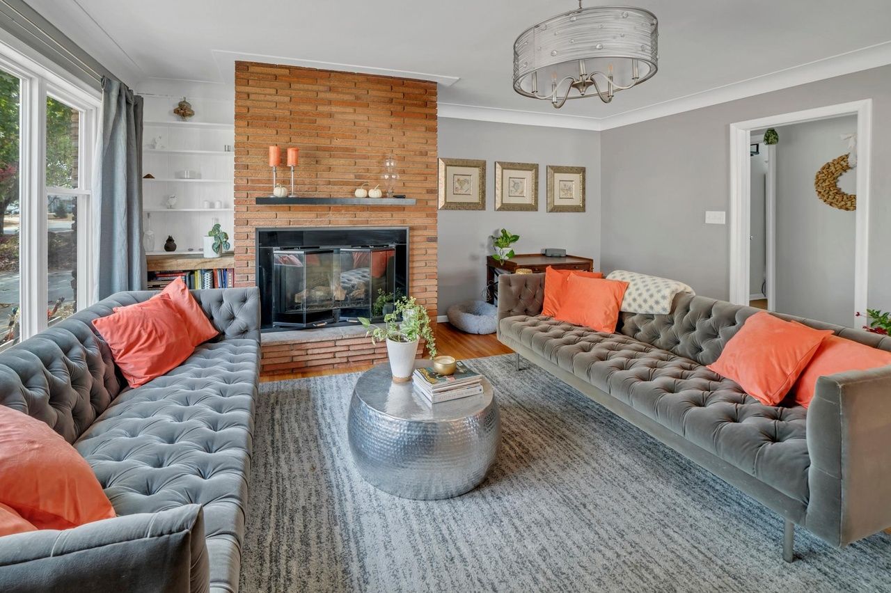 modern living area with stone fireplace and large windows